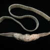 Cinturón de plata en tejido de malla, y ajustable a distintas tallas de cintura y hebilla con decoraciones orgánicas y repujadas orientales.
