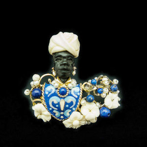 Anillo joya de diseño especial con un moretto veneciano detallado con ébano. esmalte policromado, coralitos, y espuma de mar y en acabados dorados.