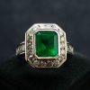 Anillo piedra de oro blanco francés de 18k con una esmeralda natural colombiana de aproximadamente 3,50ct engarzado en chatón, enmarcado por 18 brillantes