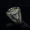 Anillo plata tipo sello con la simbología del Ojo de Horus y el brazo ornamentado con la imagen farónica todo con acabados avejentados.