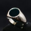 Anillo de plata estilo sello con un ónix central ovalado y el brazo de acabados lisos.