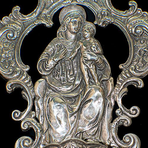 Benditera antigua con la representación de La Virgen María y Jesús en imagen de Maternidad, de acabados cincelados, repujados y patina de años