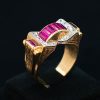 Anillo chevalier de oro amarillo de 18k, de época, con 8 rubies talla baguette con un peso total de 1.44ct y una pequeña orla de 18 diamantes con un peso total de 0.72ct.