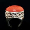 Anillo de plata con una cornalina central con facetas y brazo de acabados calados y lisos